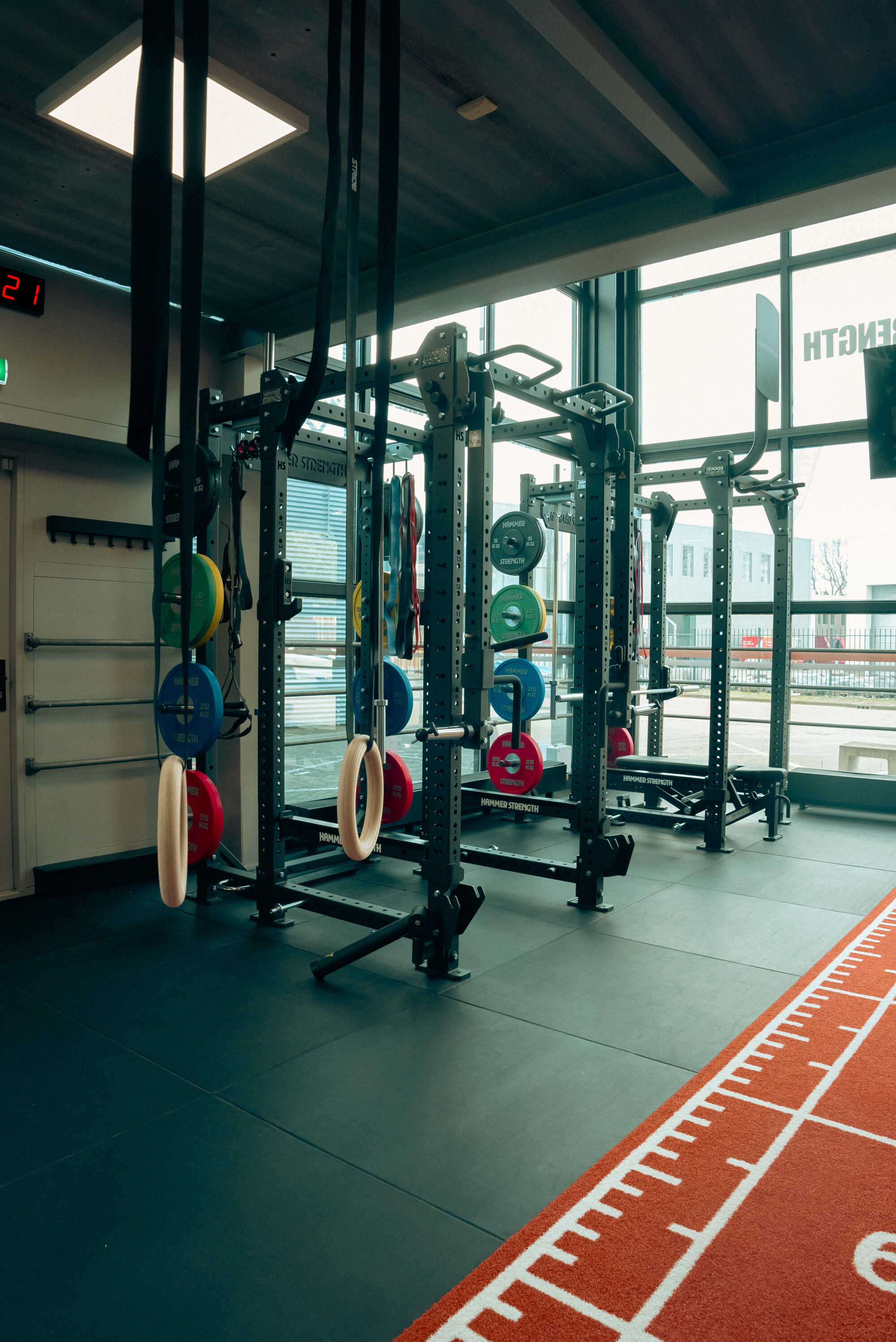 Trainingsrekken met gymnastiekringen en halterschijven naast de sprintbaan Trainingsrekken met gymnastiekringen en halterschijven naast de sprintbaan