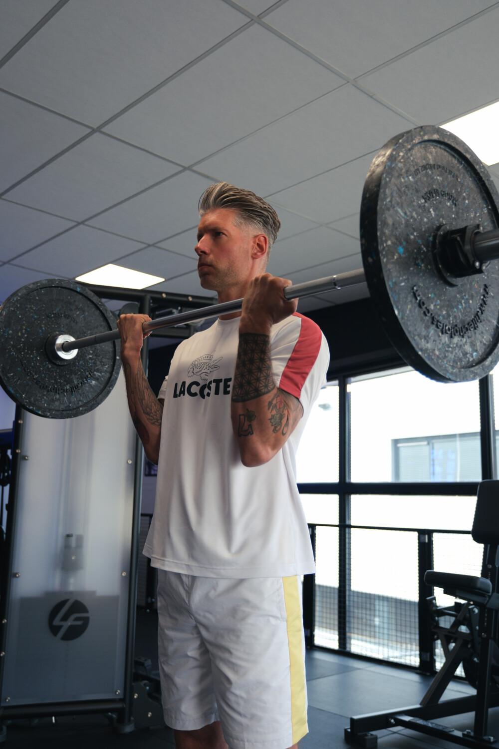 Sporter doet een biceps curl met een halterstang