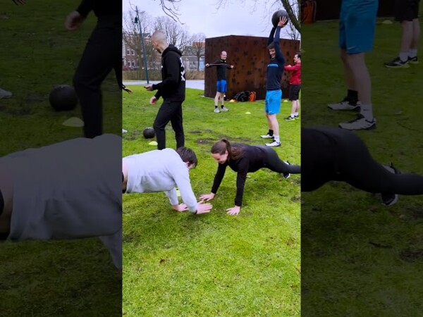 Deelnemers doen samen oefeningen op het gras tijdens een bedrijfsbootcamp