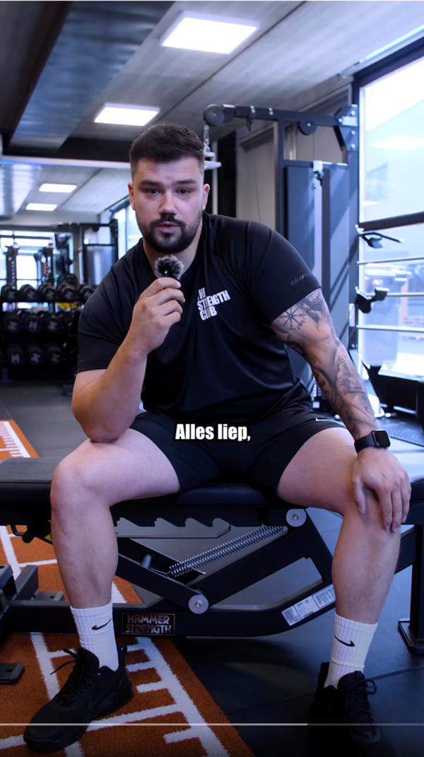 Lid vertelt met een microfoon over zijn ervaring bij The Strength Club Lid vertelt met een microfoon over zijn ervaring bij The Strength Club